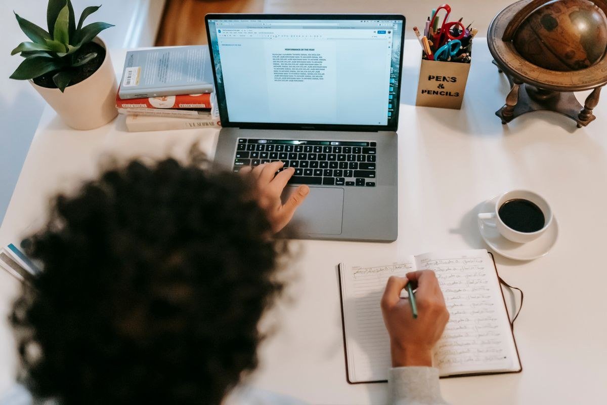 Brevo for bloggers — writer at a desk with a laptop, notebook and coffee, building an email list.