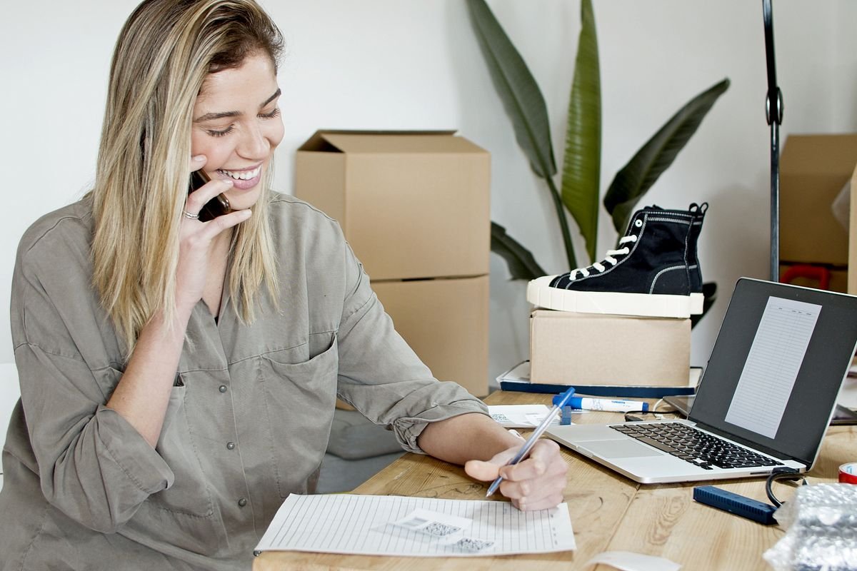 Constant Contact for small business — small business owner on the phone managing orders on a laptop